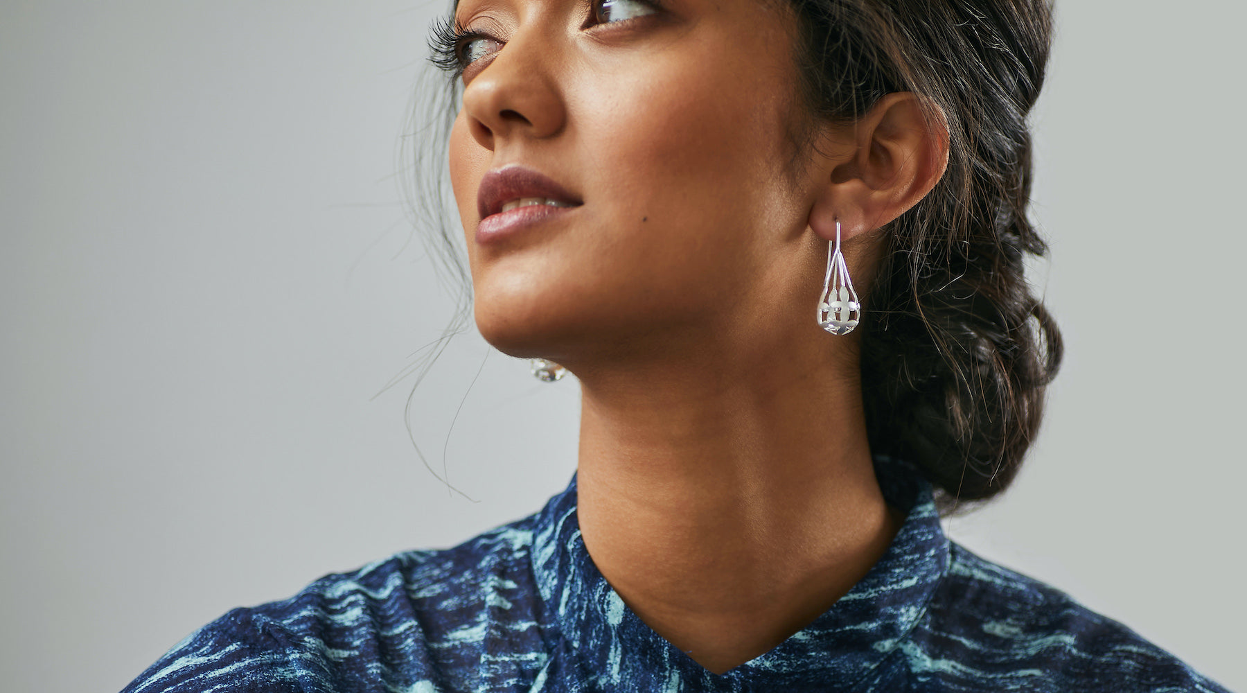 Woman looking thoughtfully sideways wearing Brave Edith Thanaka Leaf Drop Earrings in Sterling silver