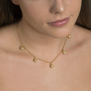 close up of woman wearing gold lotus bud necklace 