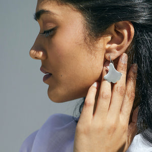 Woman wearing Plume Hook earrings in sterling silver looking to the side