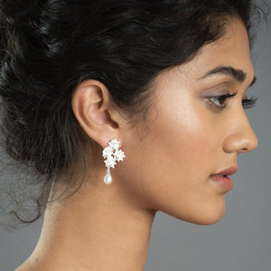 Woman wearing silver four lotus pearl earrings 
