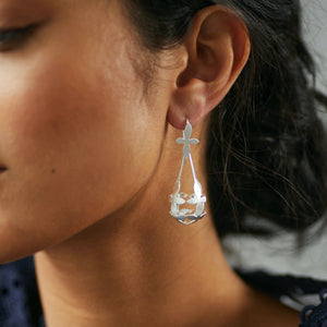 woman wearing Brave Edith Thanaka Leaf Chandelier earrings in silver