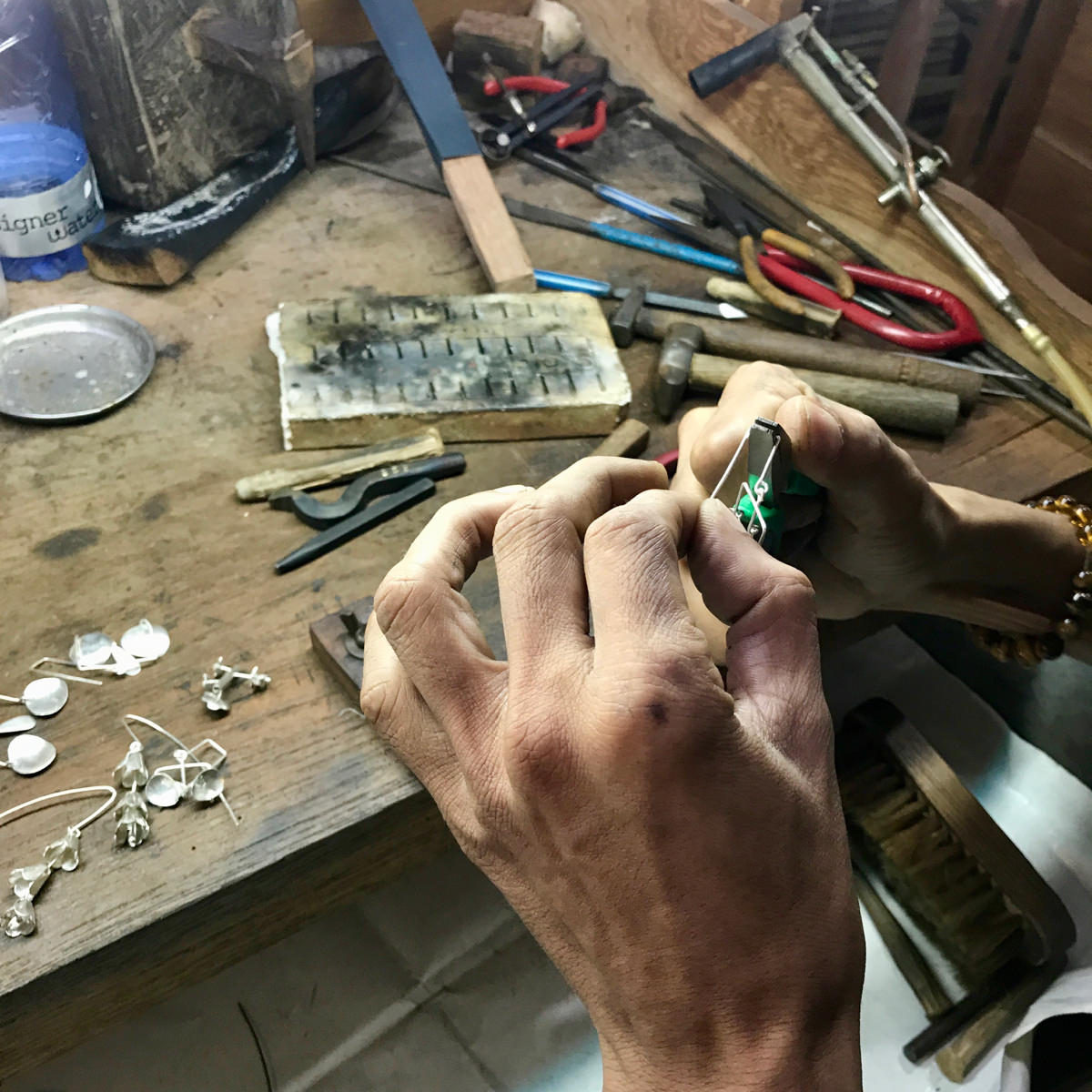 artisan's hands at jewellery bench