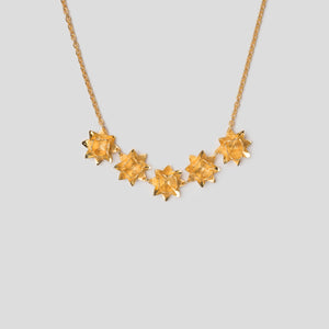 Close up gold five lotus flowers on necklace
