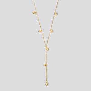 Detail of Gold lotus bud lariat necklace on white background