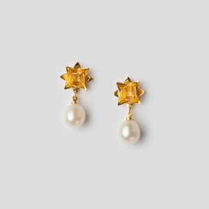 Front of gold lotus pearl earrings on white background