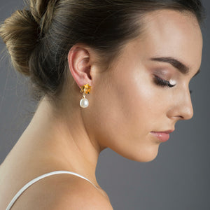 woman wearing gold lotus pearl earrings 