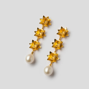 gold triple lotus earrings with pearls on angle on white background