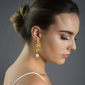 woman wearing gold triple lotus earrings with pearls 