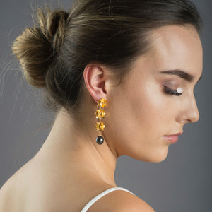 woman wearing gold triple lotus earrings with tahitian pearls