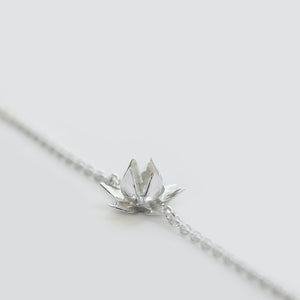 Close up of lotus flower on Long Lotus necklace in Sterling silver on white background