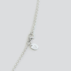 Close up of hallmark  on Long Lotus necklace in Sterling silver on white background
