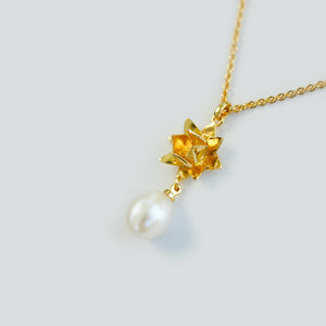 Close up of 18K gold vermeil lotus Pearl pendant by Brave Edith on white background