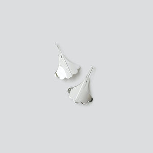 Polished backs of Plume Hook earrings in sterling silver on white background