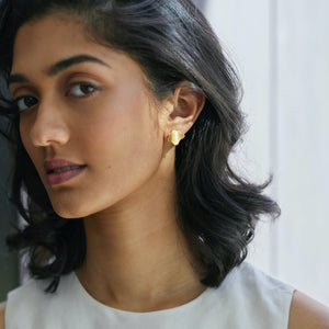 Woman wearing Plume single fan earrings in gold vermeil