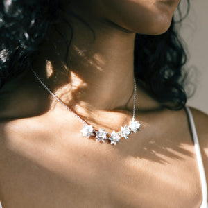 sun shining on close up of woman wearing five lotus bloom necklace