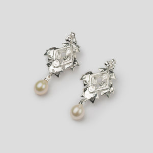 Back of silver four lotus pearl earrings on white background
