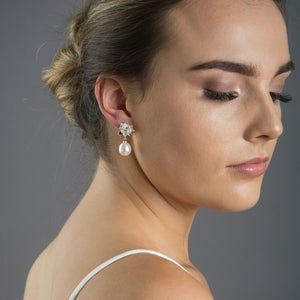 close up of woman wearing silver lotus pearl earrings 