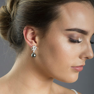 close up of woman wearing silver lotus earrings with Tahitian pearl 