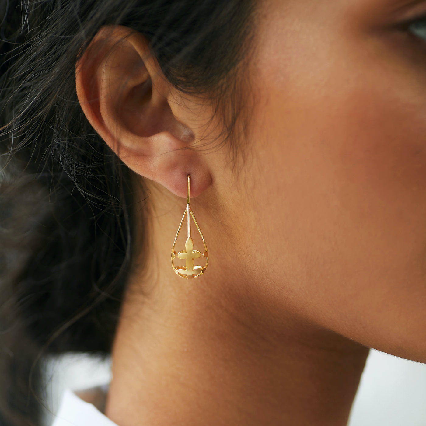 Side view of Brave Edith Thanaka Leaf Drop earrings in gold vermeil on white background